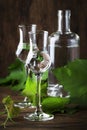 Grape vodka, pisco - traditional Peruvian strong alcoholic drink in elegant glasses on vintage wooden table, copy space