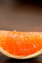 Grapefruit closeup section slice on dark oak wood table