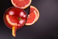 Grapefruit cocktail in a glass with ice cubes on a black background. Copy space. Top view. Royalty Free Stock Photo