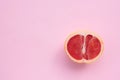 Grapefruit cut in half on a pink background. Close-up of citrus fruit on a colored backdrop. Top view. Copy space Royalty Free Stock Photo