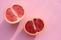 Grapefruit cut in half on a pink background. Close-up of citrus fruit on a colored backdrop. Top view. Copy space Royalty Free Stock Photo