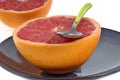 Grapefruit cut in half on a plate with a spoon close-up Royalty Free Stock Photo