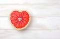 grapefruit fruit slice heart shape on white wooden table top view