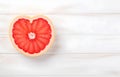 grapefruit fruit slice heart shape on white wooden table top view