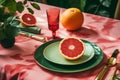 grapefruit on a green plate on a pink tablecloth