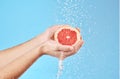 Grapefruit in hands, water splash and studio background for healthy, vegan and wellness food on advertising, marketing Royalty Free Stock Photo