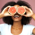 Grapefruit, happy and black woman covering her eyes in studio on a pink background. Funny, fruit and African