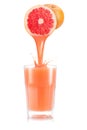 Grapefruit juice pouring out from fruit into glass