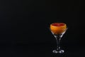 Grapefruit in a martini glass on a black background.