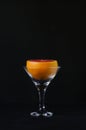 Grapefruit in a martini glass on a black background.