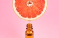 Grapefruit pure essential oil dripping into dark bottle