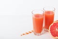 Grapefruit refreshing juice with straws on a white background with grapefruit slices. Summer refreshing diet drink Royalty Free Stock Photo