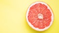 Grapefruit in section closeup, on yellow background Royalty Free Stock Photo
