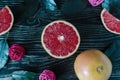 Grapefruit slices grapefruit decorative elements and green leaves on a dark wooden background