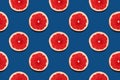 Grapefruit slices seamless pattern on classic blue background summer year 2020 juicy color. Royalty Free Stock Photo