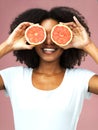 Grapefruit, smile and black woman cover her eyes in studio isolated on a pink background. Natural, fruit and African