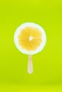 Grapefruit sweetie icecream with wood stick on light green background. Creative summe fruity popsicle sticks