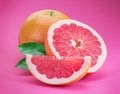 Grapefruits and grapefruit slices isolated on pink background Royalty Free Stock Photo