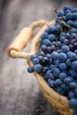 Blue grapes on the basket on the wooden table