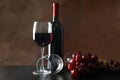 Grapes, bottle and glass with wine against brown background