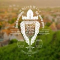 Grapes bunch with wineglass for text in the center on blurred background with vineyards and town