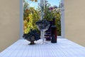 Grapes and flowers in vases and a bottle of wine on the table near the window Royalty Free Stock Photo