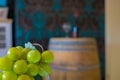 grapes in front of a wine bottle on an oak barrel Royalty Free Stock Photo