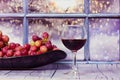 Grapes, glass of red wine on a table against window. Still Life fruit Alcoholic.