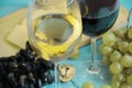 Grapes, a glass of wine nut autumn rustic beverage cheese on a blue wooden backgrounnut