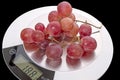 Grapes on kitchen scale Royalty Free Stock Photo