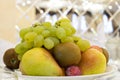 Grapes, pear, kiwi, plum, apple in a plate. Dessert fruit platter. Table setting in a restaurant or cafe Royalty Free Stock Photo