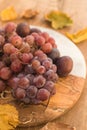 Grapes and plums on half-wooden half-marble plate