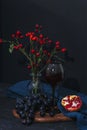 Grapes, pomegranate and drink in a wineglass on black background. Still life. Selective focus, shallow depth of field Royalty Free Stock Photo