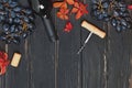 Grapes, red wine in a bottle and autumn leaves on the black wooden table Royalty Free Stock Photo