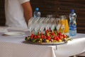 Grapes and strawberries lay on the plate behind empty wineglasses