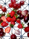 Grapes and strawberries are scattered on a black and white polygon background