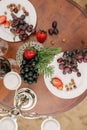 Grapes and strawberries on white plates and scattered on a wooden round table. Top view Royalty Free Stock Photo