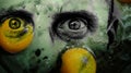 Graphic art with the face of a man with worried eyes and green skin covered with two egg yolks