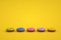 Graphic 3d models of glazed donuts on a yellow isolated background. Models of different colored donuts lying in a row