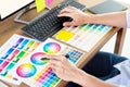 Graphic designer or creative holding Mouse and do his work material color pantone swatch samples art tools at desk in office