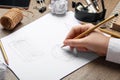 Graphic designer drawing geometry shapes at table, closeup