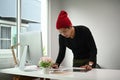 A Graphic designer man in red wool hat is working on his new project . Royalty Free Stock Photo