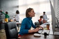 Graphic designer at work. Side view of young woman using digital graphics tablet while sitting at her workplace in the Royalty Free Stock Photo