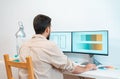 Graphic designer working in phone app with his computer and digital tablet in a modern home office. Royalty Free Stock Photo