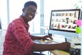 Graphic designer working on graphic tablet at desk in office