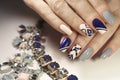 Graphic nail design on beige, transparent blue and dark matte blue nail Polish Royalty Free Stock Photo