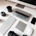 Graphics tablet, camera, laptop, black cup, objects, keyboard, mobile phone and wireless mouse on a white wooden table. Royalty Free Stock Photo