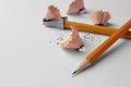 Graphite pencils, shavings and sharpener on white background, closeup. Space for text Royalty Free Stock Photo