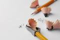 Graphite pencils, shavings and sharpener on white background, closeup. Space for text Royalty Free Stock Photo