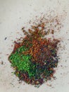 Graphite shavings of various colors with poignant green spread on a white background